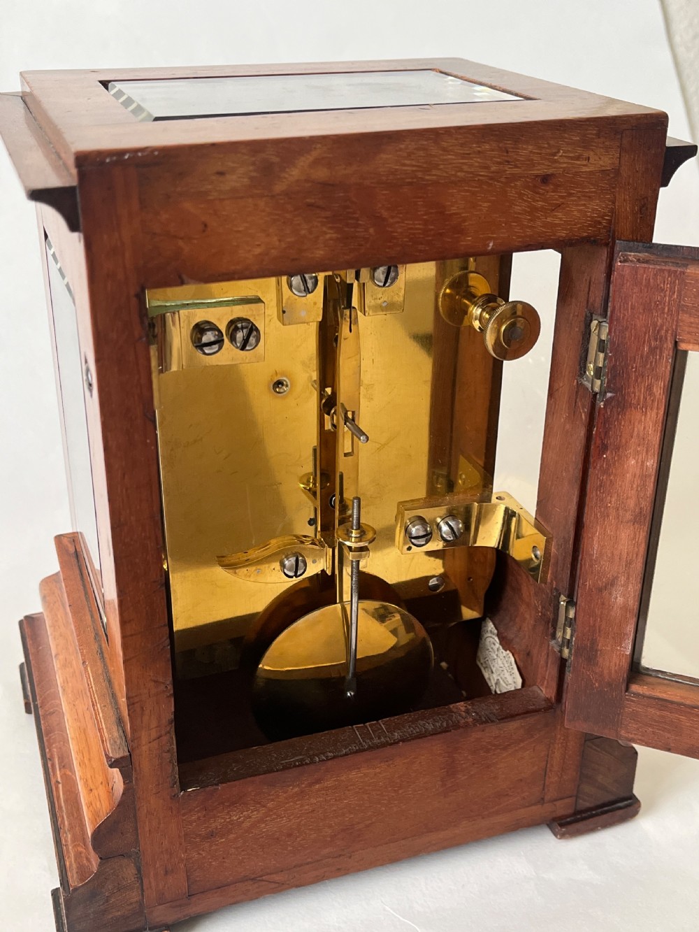 A Victorian mahogany library clock featuring a square timber case with a silvered engraved dial, black Roman numerals, and a key visible on the side. View III