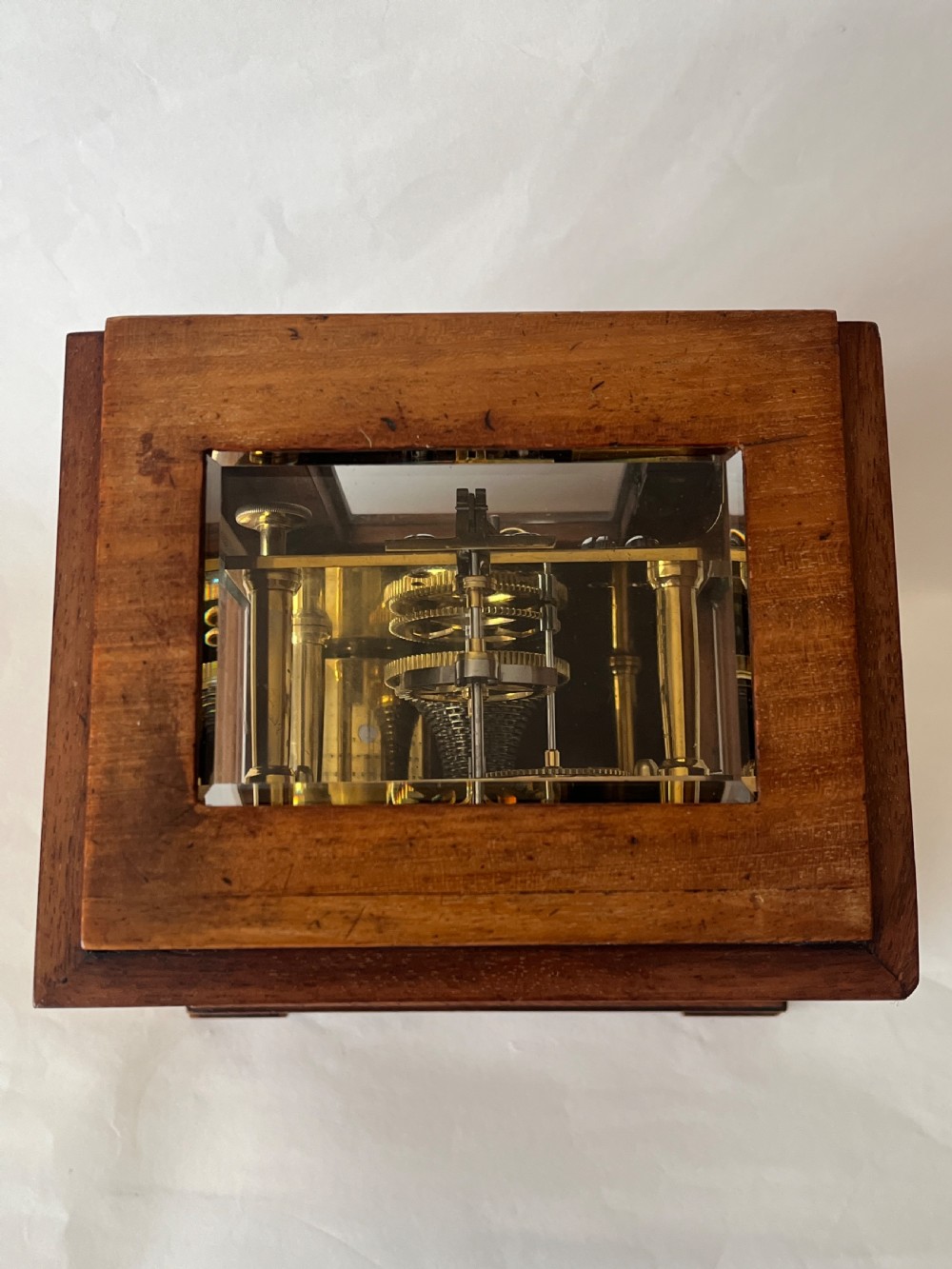 A Victorian mahogany library clock featuring a square timber case with a silvered engraved dial, black Roman numerals, and a key visible on the side. View VII