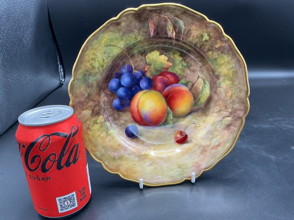 A circular bone china cabinet plate hand-painted with peaches and grapes against a mossy background, featuring a scalloped gilt rim. View III
