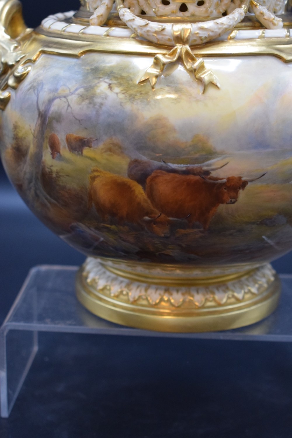 A gilded porcelain pot pourri vase with a pierced cover, twin scroll handles, and a painted landscape featuring Highland cattle. View V