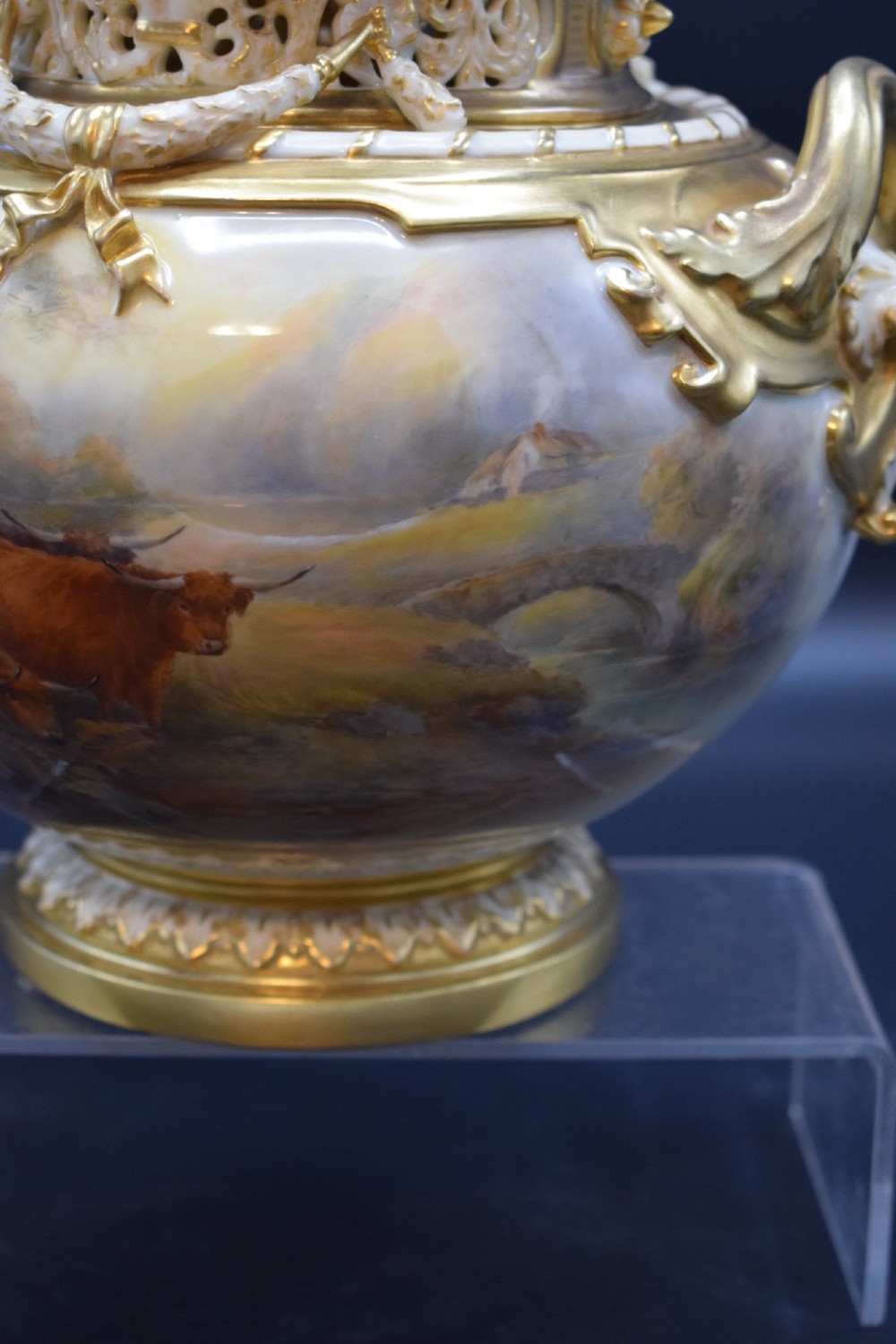 A gilded porcelain pot pourri vase with a pierced cover, twin scroll handles, and a painted landscape featuring Highland cattle. View VI