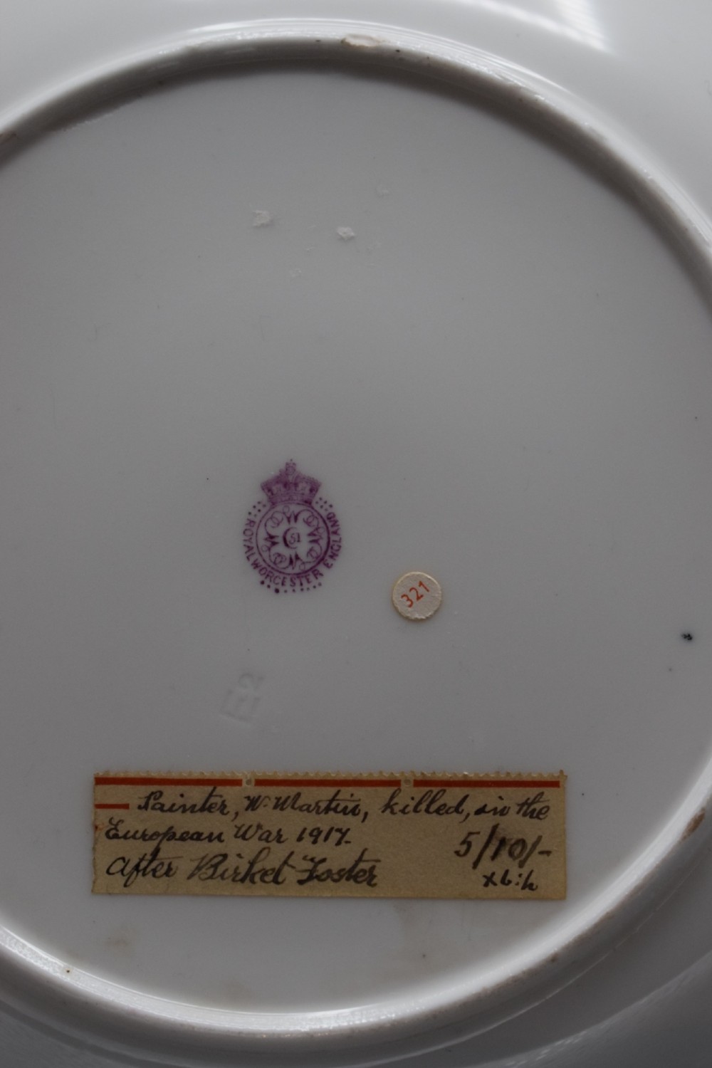A pair of circular porcelain plates decorated with hand-painted pastoral landscapes and framed by wide cream borders with intricate gilded detailing. View VI