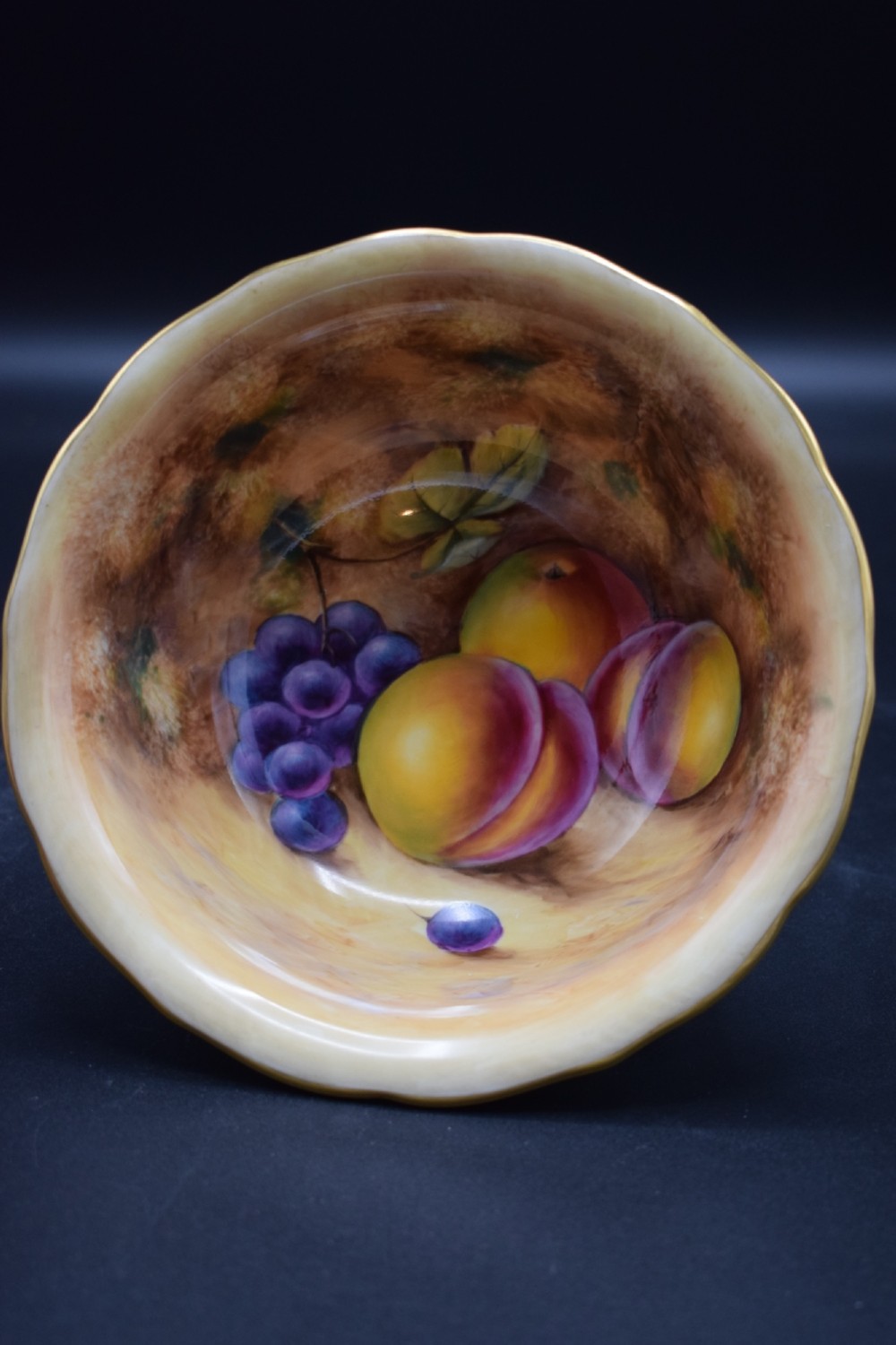 A pair of circular porcelain bowls featuring hand-painted peaches and grapes with gilded rims. View II