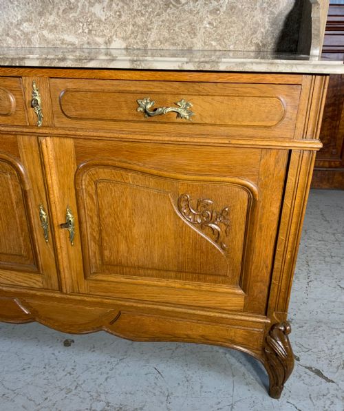 fig 1. A carved oak French dressing table featuring a marbled stone top, a matching splashback shelf, an attached three-panel triptych mirror, and two drawers above a two-door cabinet.