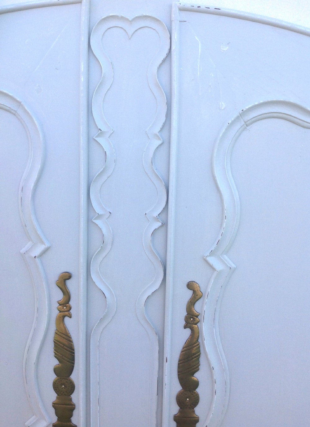 A pair of pale grey painted cherrywood doors featuring serpentine Louis XV moulding and elaborate brass handles. View II