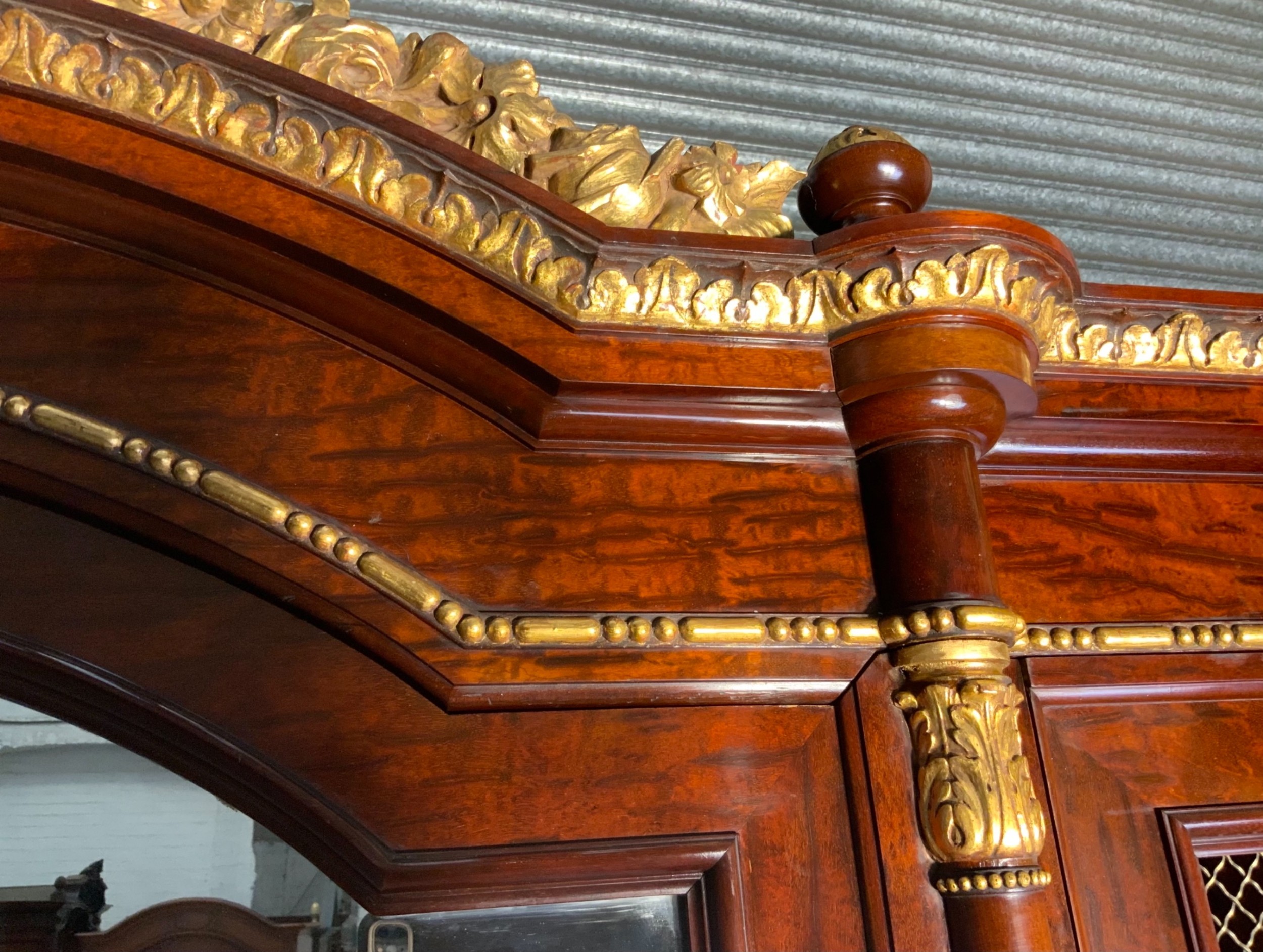 A large mahogany three-door armoire featuring a central arched mirrored door, wire-mesh side panels, and gilt bronze mounts. View VI