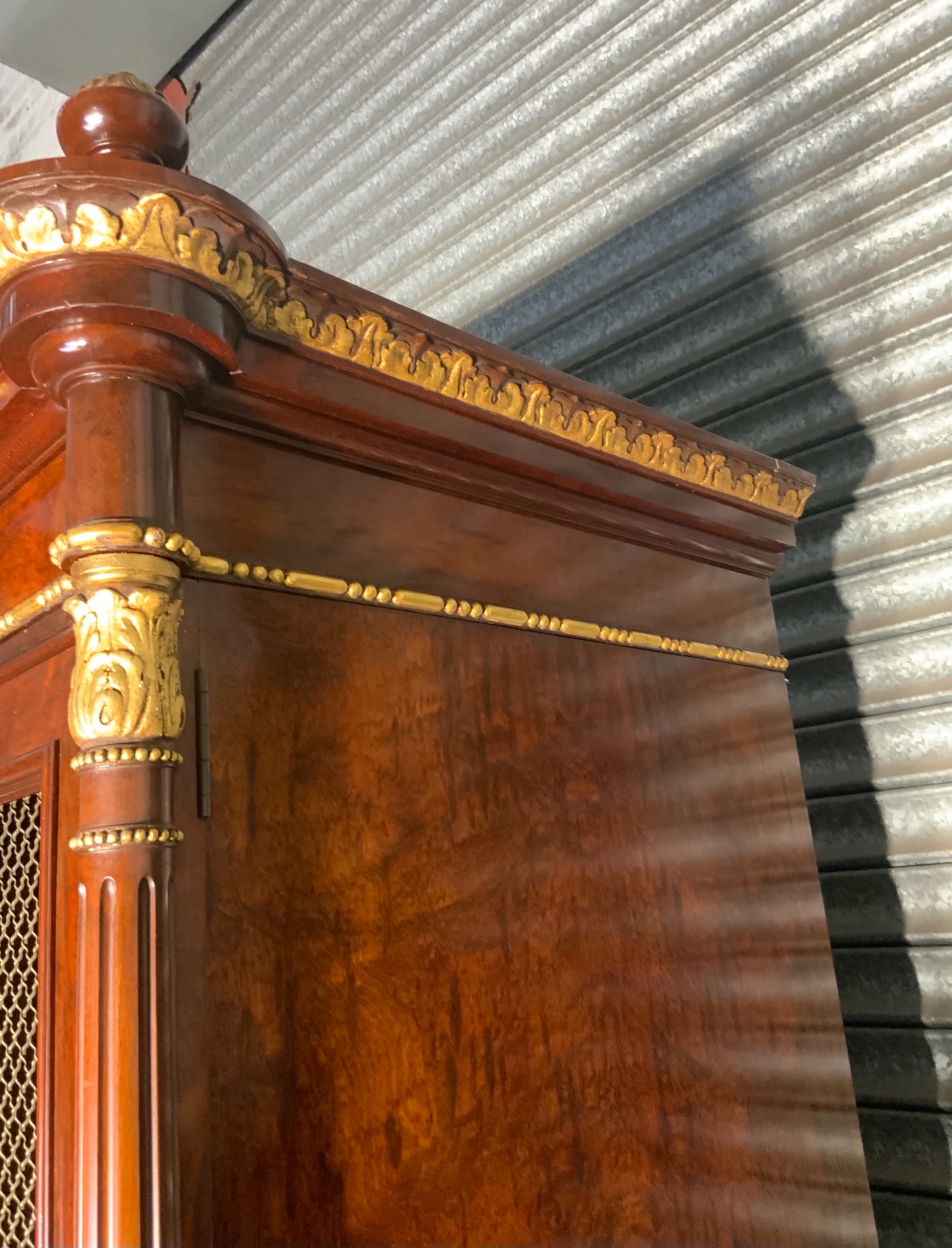 A large mahogany three-door armoire featuring a central arched mirrored door, wire-mesh side panels, and gilt bronze mounts. View X