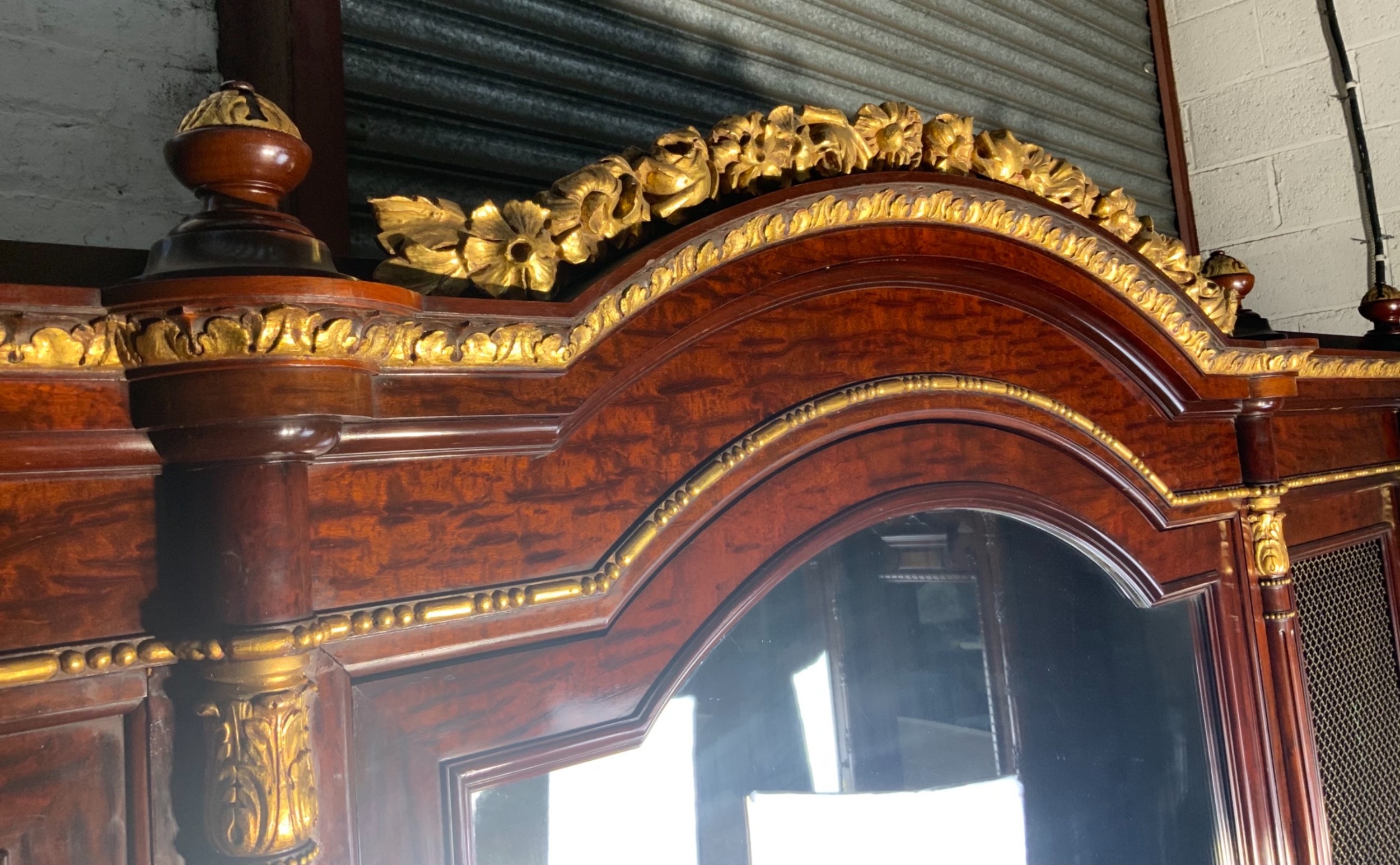 A large mahogany three-door armoire featuring a central arched mirrored door, wire-mesh side panels, and gilt bronze mounts. View XVI