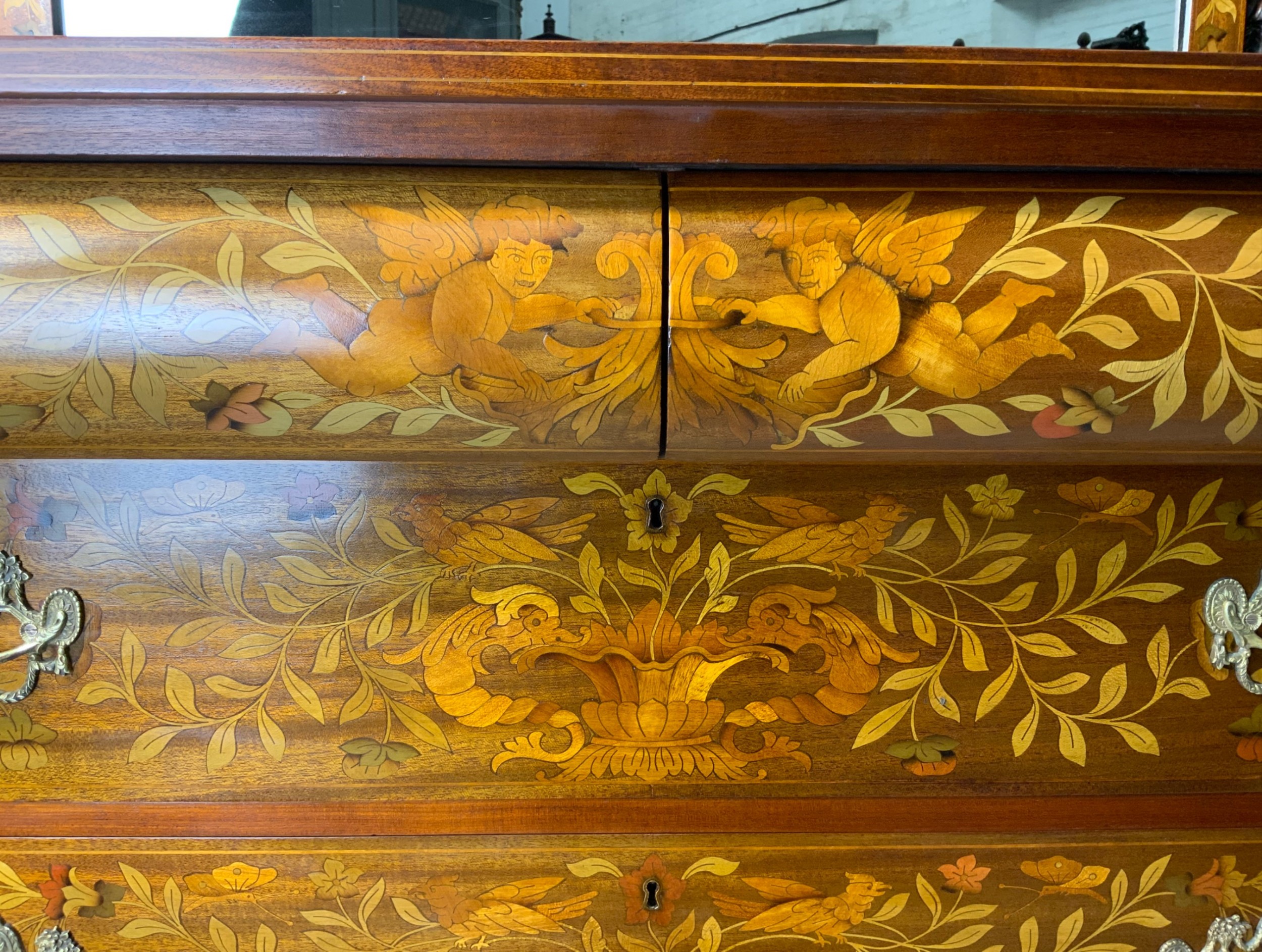 An early nineteenth-century Dutch mahogany dressing chest featuring detailed floral marquetry, three wide drawers, carved pilasters ending in paw feet, and an attached arched mirror. View IV