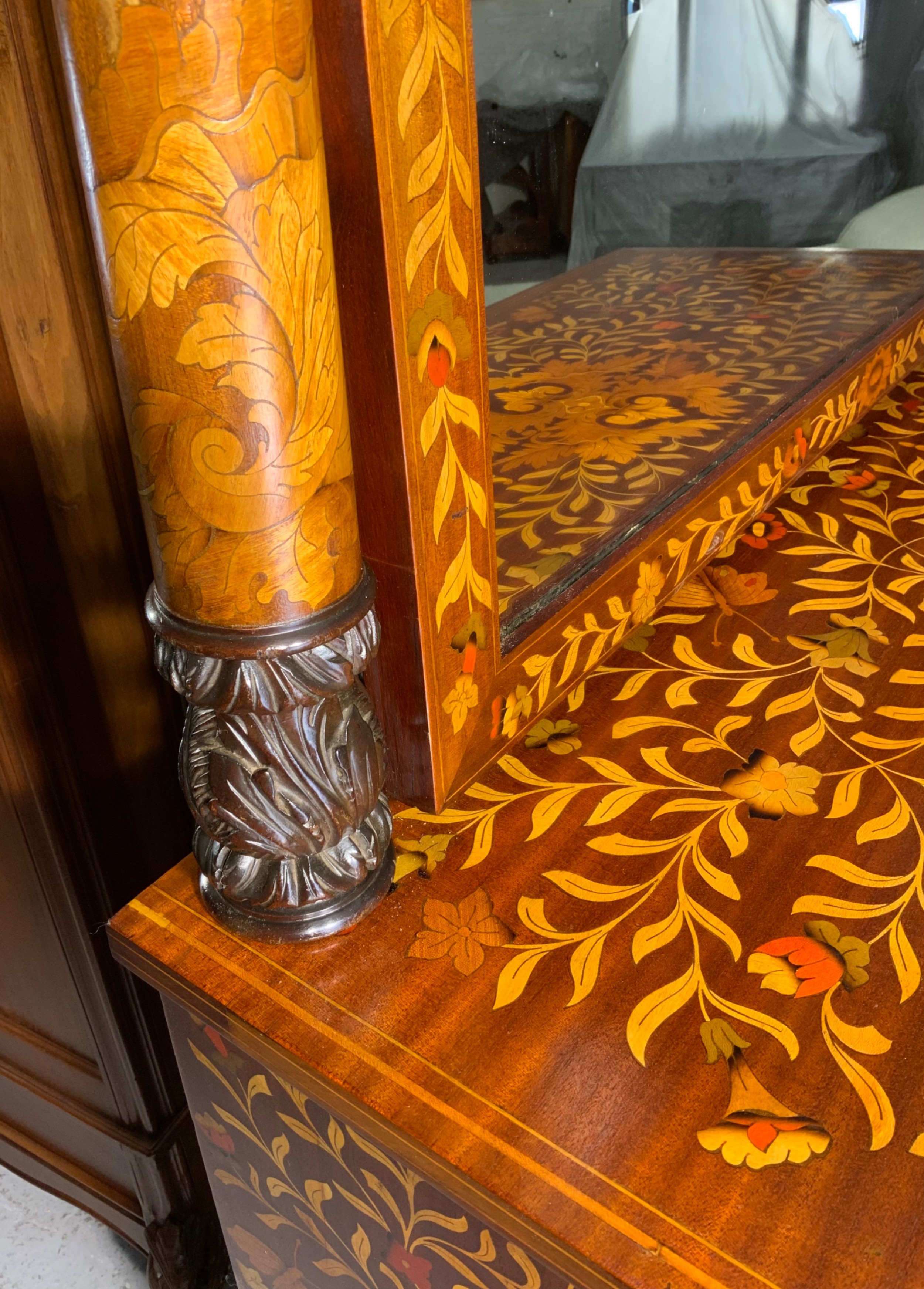An early nineteenth-century Dutch mahogany dressing chest featuring detailed floral marquetry, three wide drawers, carved pilasters ending in paw feet, and an attached arched mirror. View XX