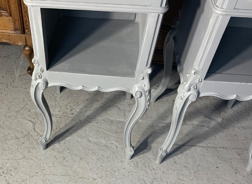 A pair of French style grey painted bedside cabinets featuring reddish-brown marble tops, single drawers with brass handles, open lower shelves, and slender cabriole legs. View III