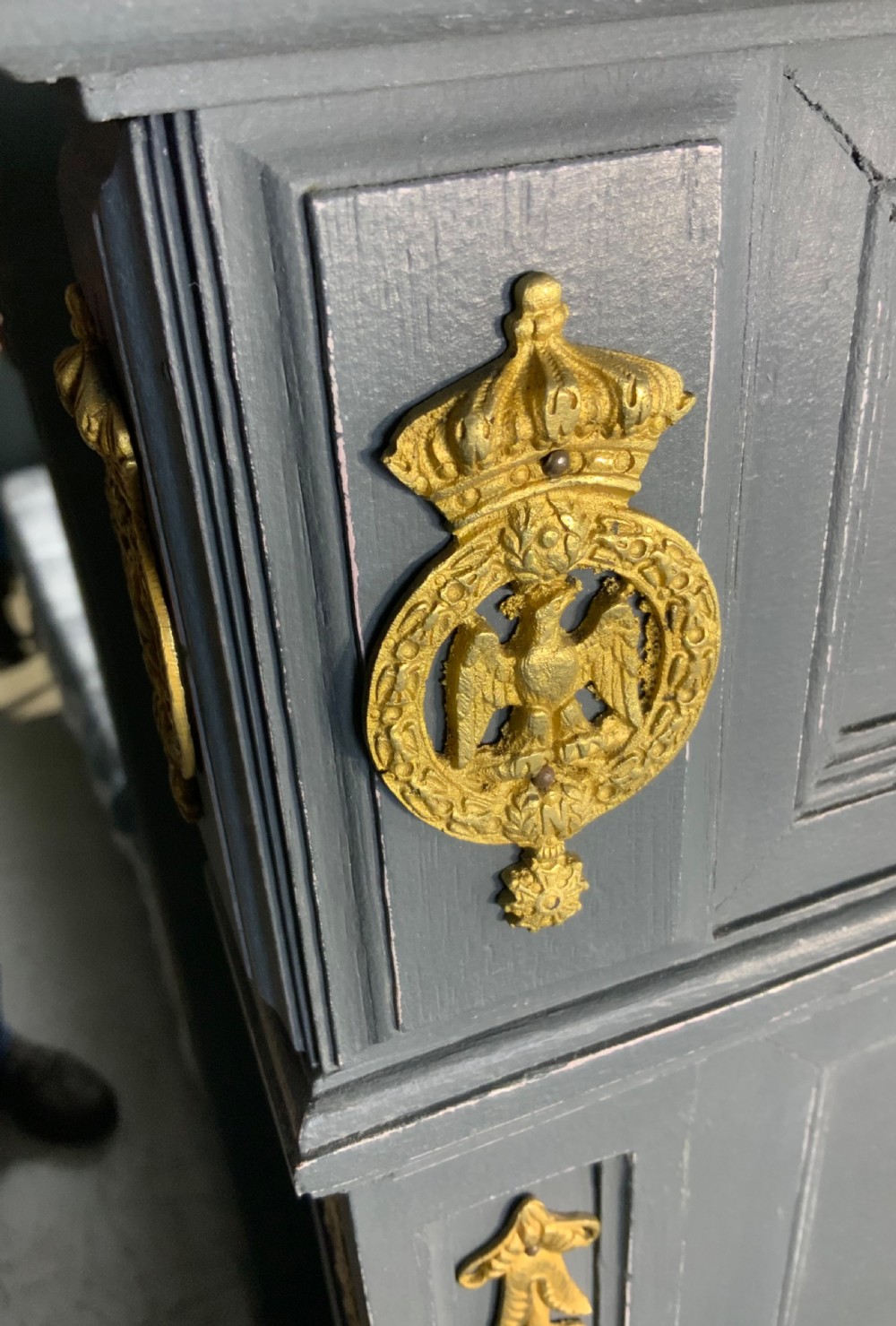 A grey painted French double bed frame decorated with gold brass mounts, featuring a central laurel wreath motif and a pediment headboard. View VII