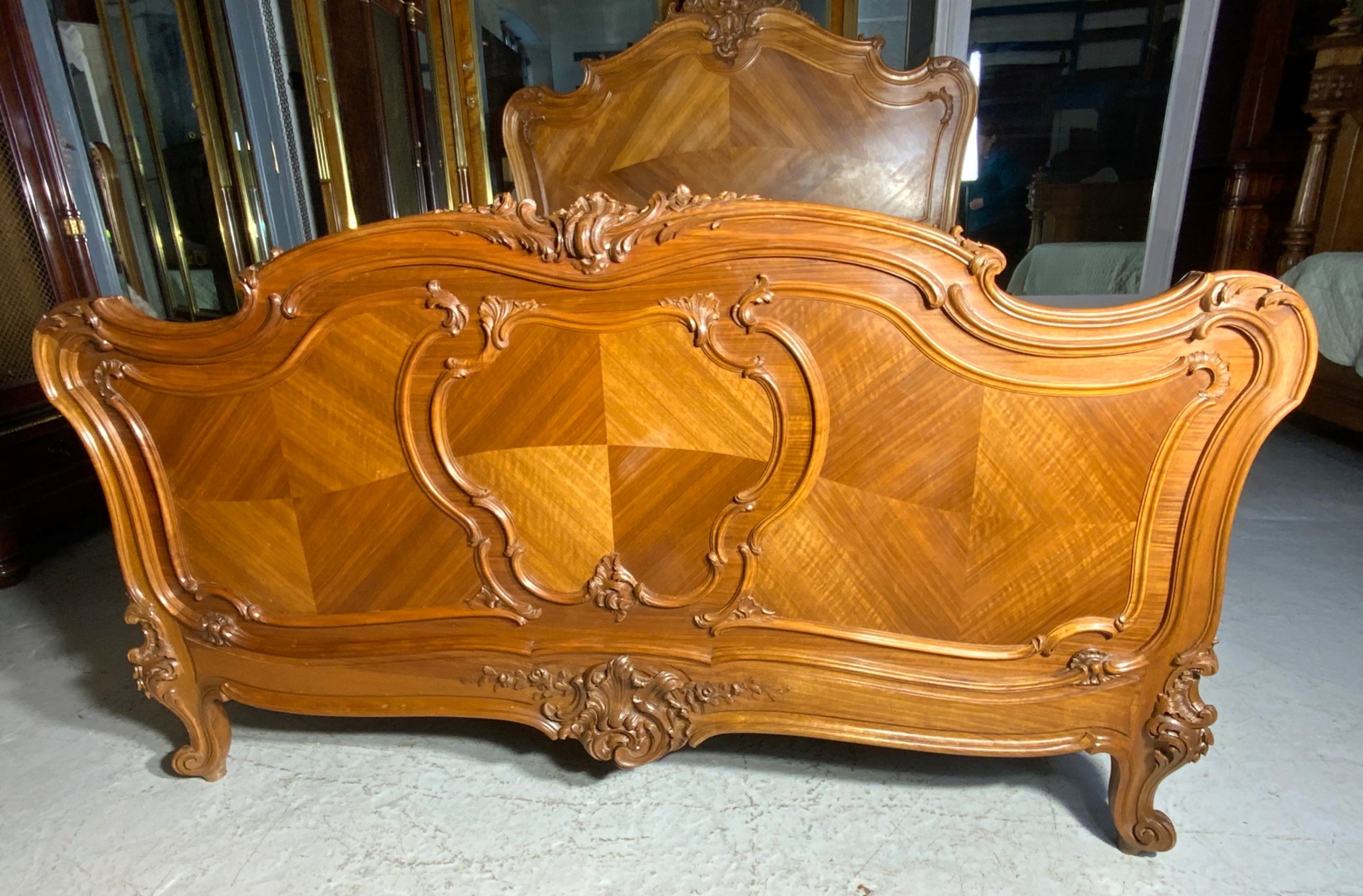 A king size French Louis XV style wooden bed frame featuring a carved crest, parquetry panelwork, and curved legs. View II