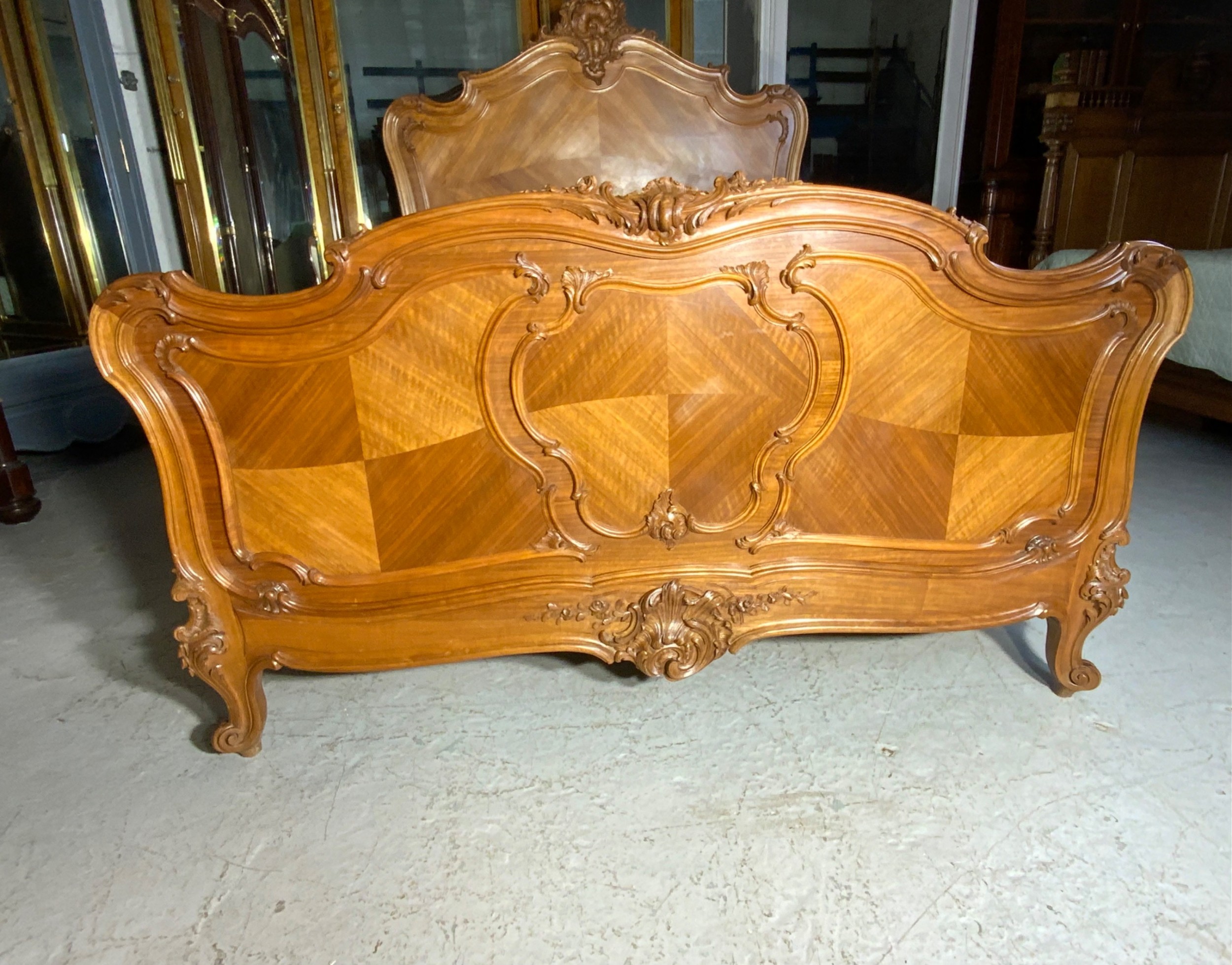 A king size French Louis XV style wooden bed frame featuring a carved crest, parquetry panelwork, and curved legs. View III