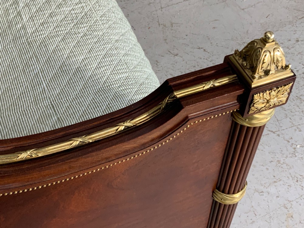 French Neoclassical mahogany bed frame featuring an oval marquetry panel, polished brass mounts, fluted columns, and two matching marble-topped bedside cabinets. View VIII