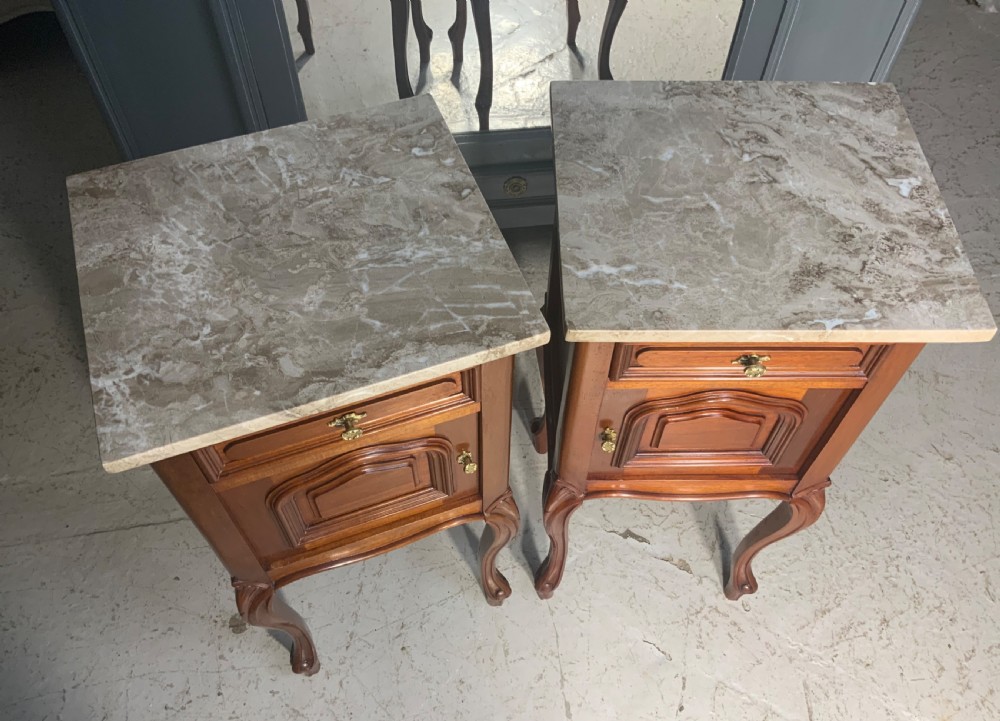 A matching pair of French mahogany bedside cabinets featuring marble tops, single upper drawers, molded cupboard doors, and cabriole legs. View VI