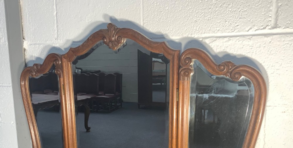 A carved oak French dressing table with a central tri-fold mirror, five carved drawers, metal handles, and curved cabriole legs. View VII