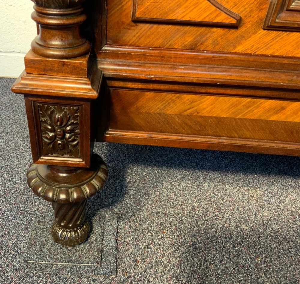 A tall 19th-century French rosewood armoire with two full-length mirrored doors, an arched pediment topped with a foliage crest carving, and fluted corner columns. View VIII