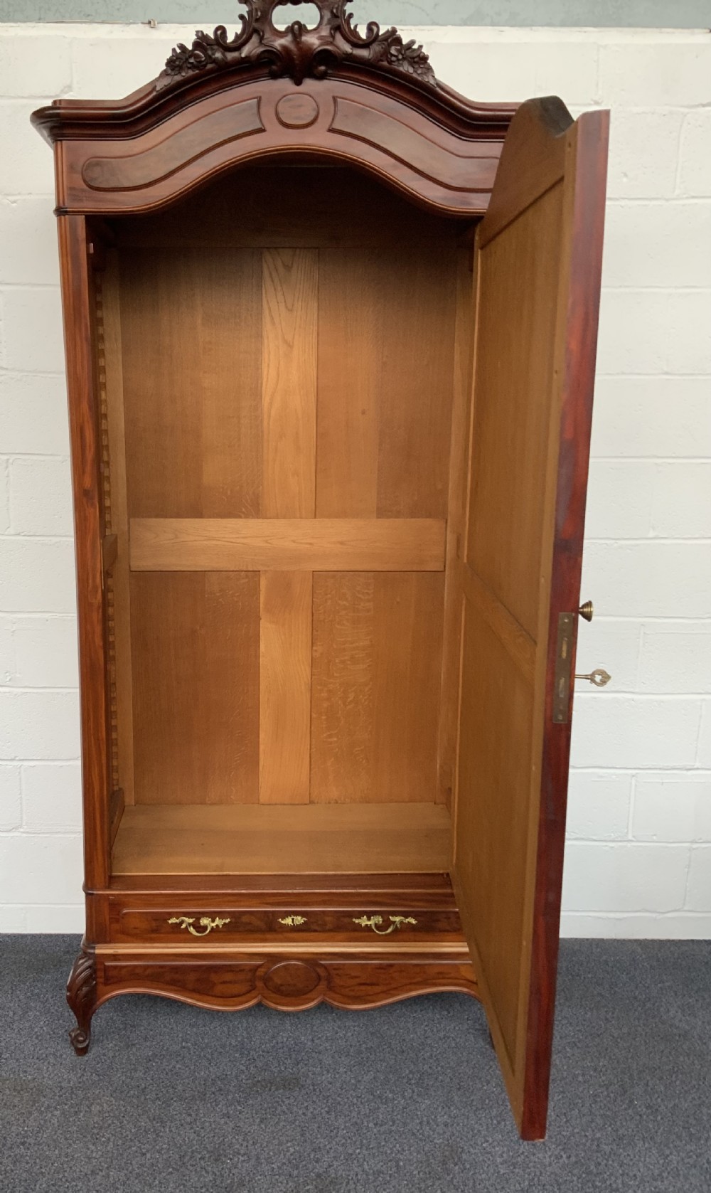A tall single-door French mahogany armoire featuring an arched mirror door, detailed floral carved cresting, a bottom drawer, and cabriole feet. View VIII