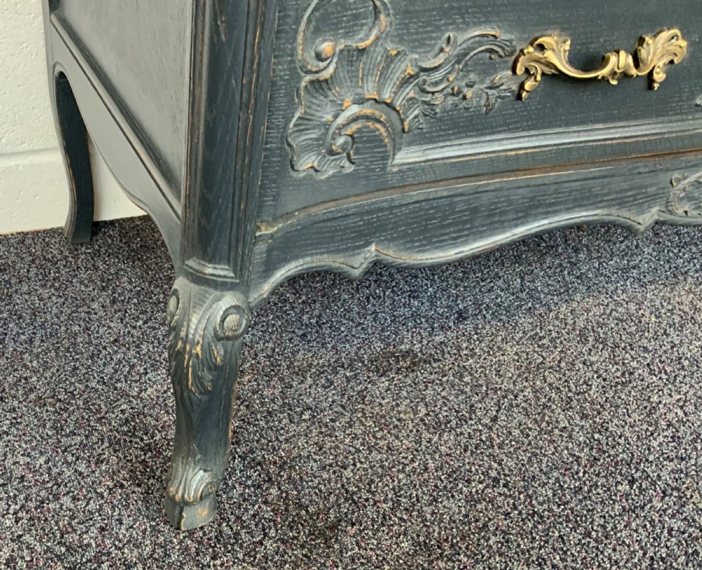 A dark grey painted French carved oak chest of drawers with three drawers and decorative brass handles. View III