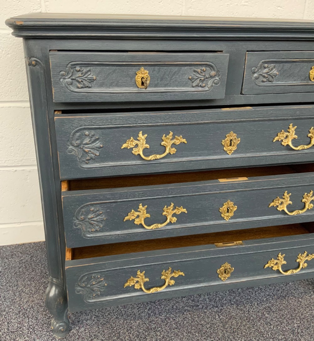 A dark grey painted French carved oak chest of drawers with decorative brass handles and carved drawer fronts. View VIII