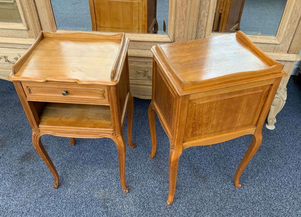 A pair of satinwood French bedside cabinets featuring raised gallery tops, single drawers over open shelves, and carved cabriole legs. View VI