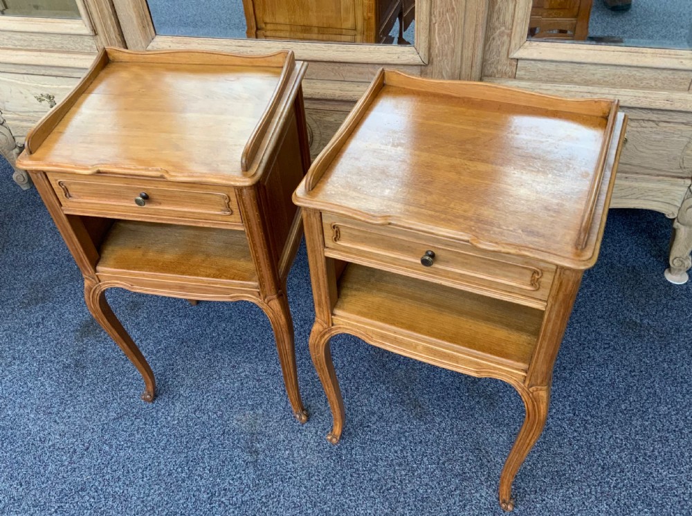A pair of satinwood French bedside cabinets featuring raised gallery tops, single drawers over open shelves, and carved cabriole legs. View VII