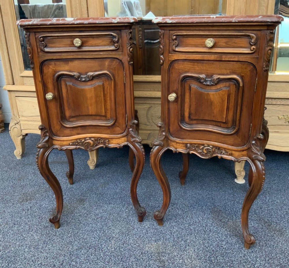 A pair of carved walnut French bedside cabinets featuring rouge marble tops, single top drawers, carved cupboard doors, and cabriole legs. View VIII