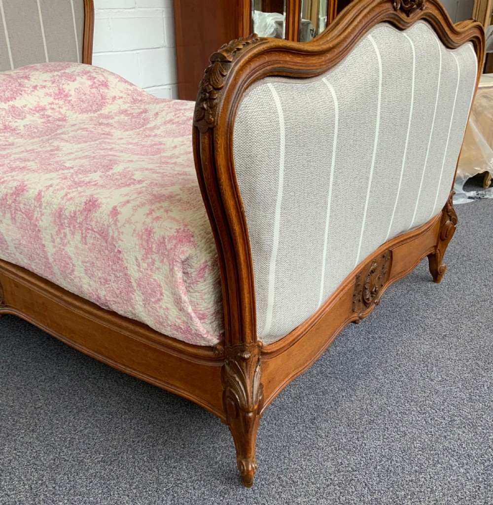 A French Louis XV style bed frame featuring carved timber contours, cabriole legs, and striped grey upholstery on the headboard and footboard. View VII