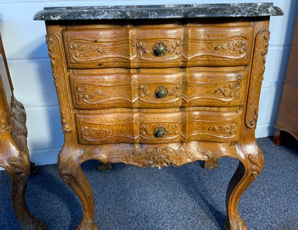 A pair of carved oak bedside cabinets featuring grey marble tops, serpentine fronts, brass handles, and cabriole legs ending in claw feet. View V