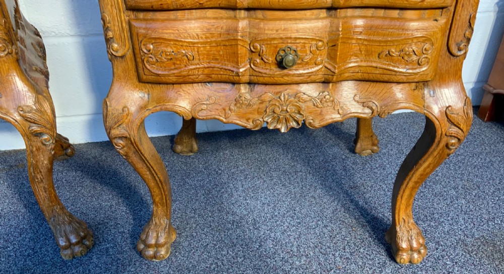 A pair of carved oak bedside cabinets featuring grey marble tops, serpentine fronts, brass handles, and cabriole legs ending in claw feet. View VI