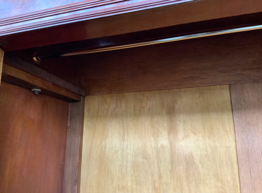 A 19th-century French mahogany armoire with flame-veneered double doors, a top moulding, two base drawers, and turned bun feet. View VI