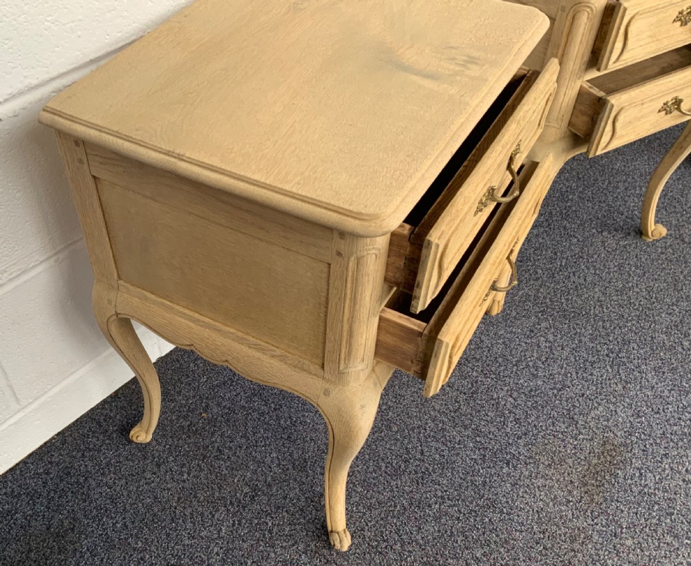 A pair of bleached oak two-drawer bedside cabinets featuring carved cabriole legs and brass handles. View IV