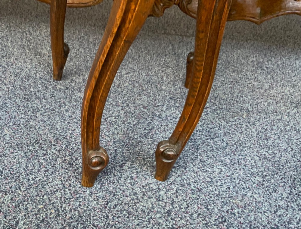 A pair of French oak bedside cabinets featuring white marble tops, single drawers, panelled doors, and carved cabriole legs. View VI