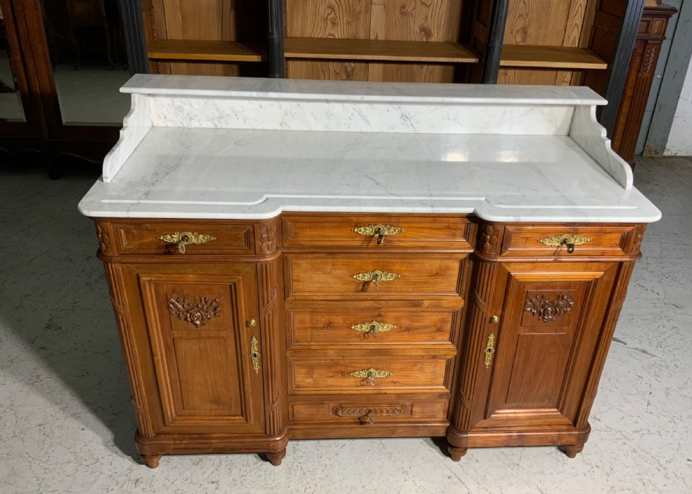 An antique mahogany French washstand featuring a white marble top, integrated arched mirror, multiple drawers, and side cupboards with brass handles. View IV