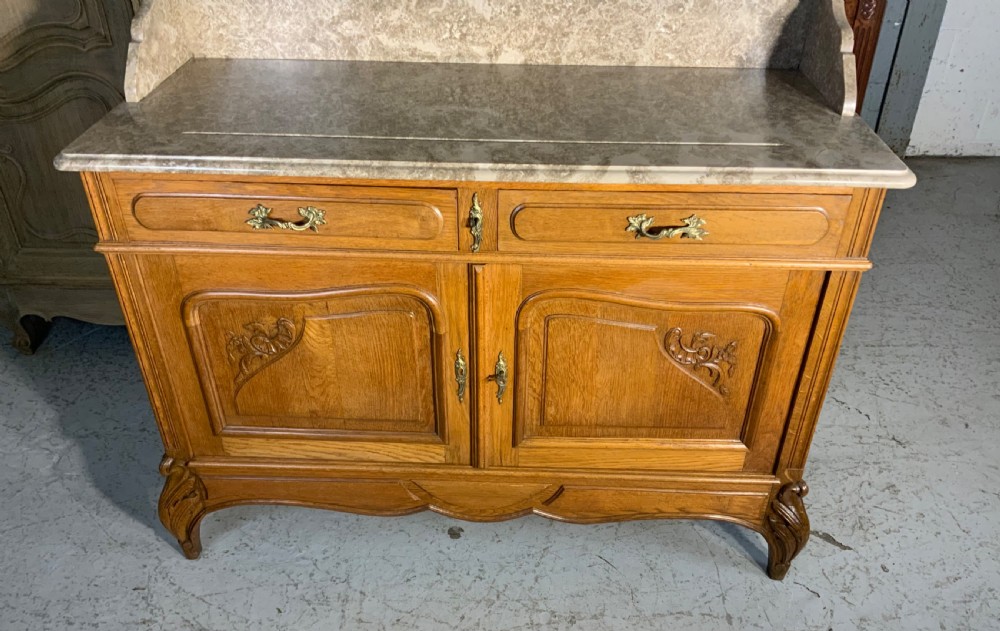 A carved oak French dressing table featuring a marbled stone top, a matching splashback shelf, an attached three-panel triptych mirror, and two drawers above a two-door cabinet. View VII