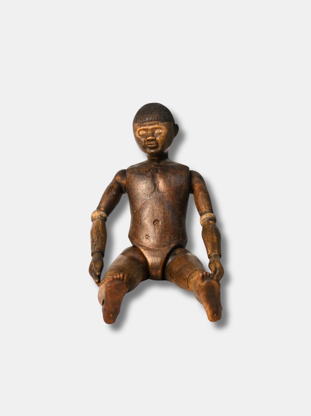 A carved dark wood articulated lay figure standing upright with jointed limbs. View III