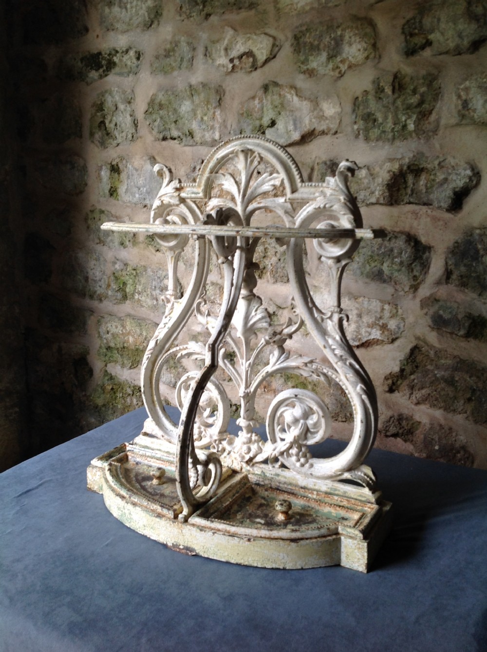 An ornate off-white painted Victorian cast iron umbrella stand with botanical scrollwork and a twin drip tray base. View III