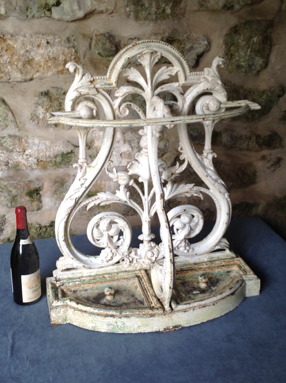 An ornate off-white painted Victorian cast iron umbrella stand with botanical scrollwork and a twin drip tray base. View VIII