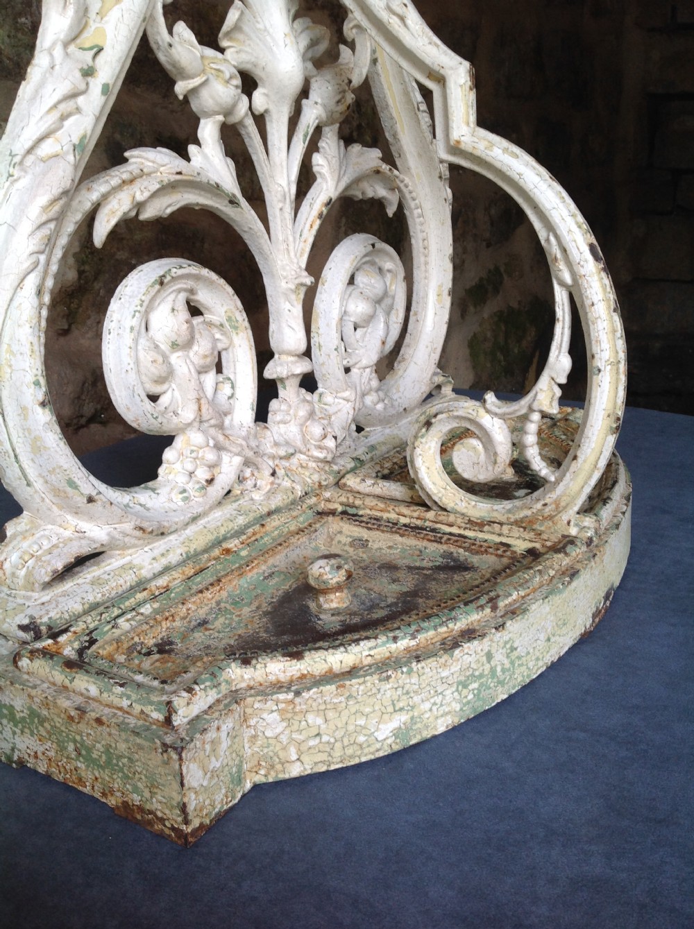 An ornate off-white painted Victorian cast iron umbrella stand with botanical scrollwork and a twin drip tray base. View IX