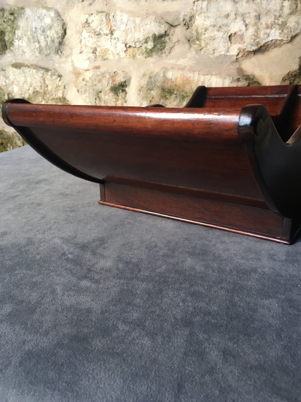 A dark mahogany Georgian cheese coaster featuring a crescent-shaped body with a central divider and scrolled ends set upon a rectangular base. View IV
