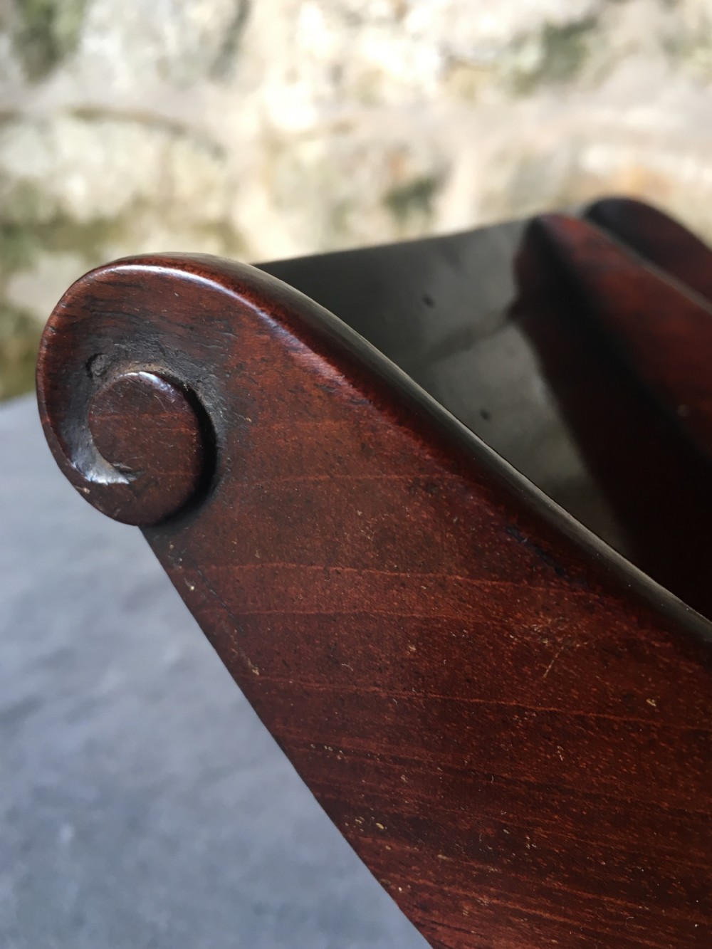 A dark mahogany Georgian cheese coaster featuring a crescent-shaped body with a central divider and scrolled ends set upon a rectangular base. View VI