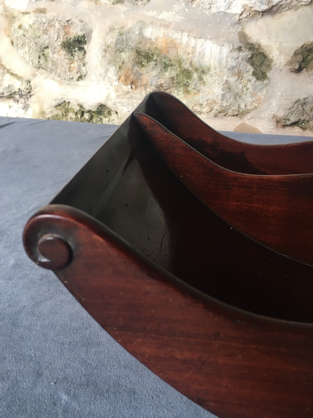 A dark mahogany Georgian cheese coaster featuring a crescent-shaped body with a central divider and scrolled ends set upon a rectangular base. View VII