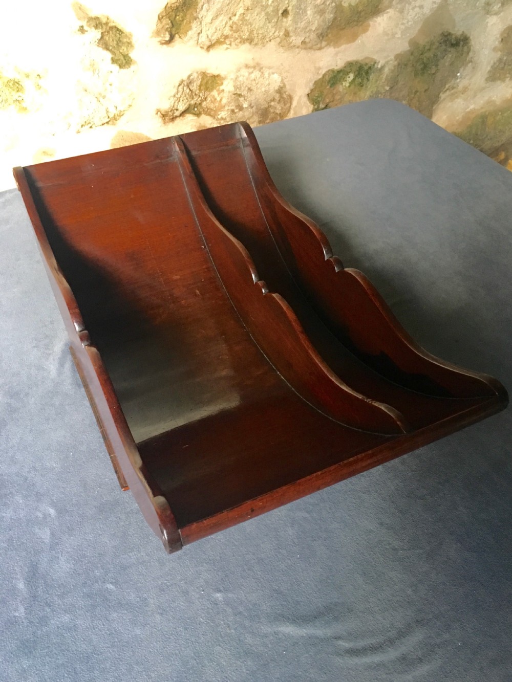 A dark mahogany Georgian cheese coaster featuring a crescent-shaped body with a central divider and scrolled ends set upon a rectangular base. View X