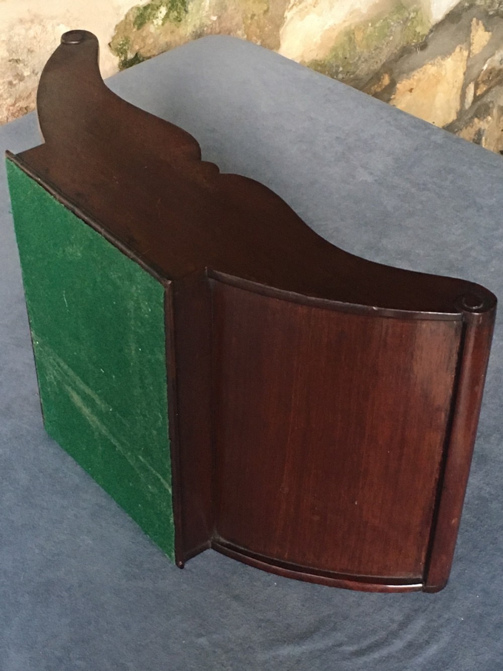 A dark mahogany Georgian cheese coaster featuring a crescent-shaped body with a central divider and scrolled ends set upon a rectangular base. View XII