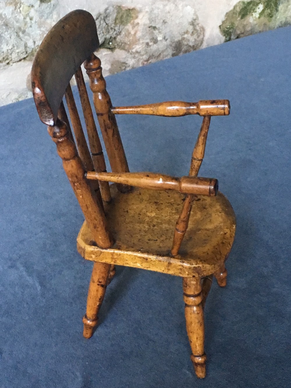 A wooden miniature Windsor armchair featuring turned spindle back supports, curved armrests, and turned legs. View VII