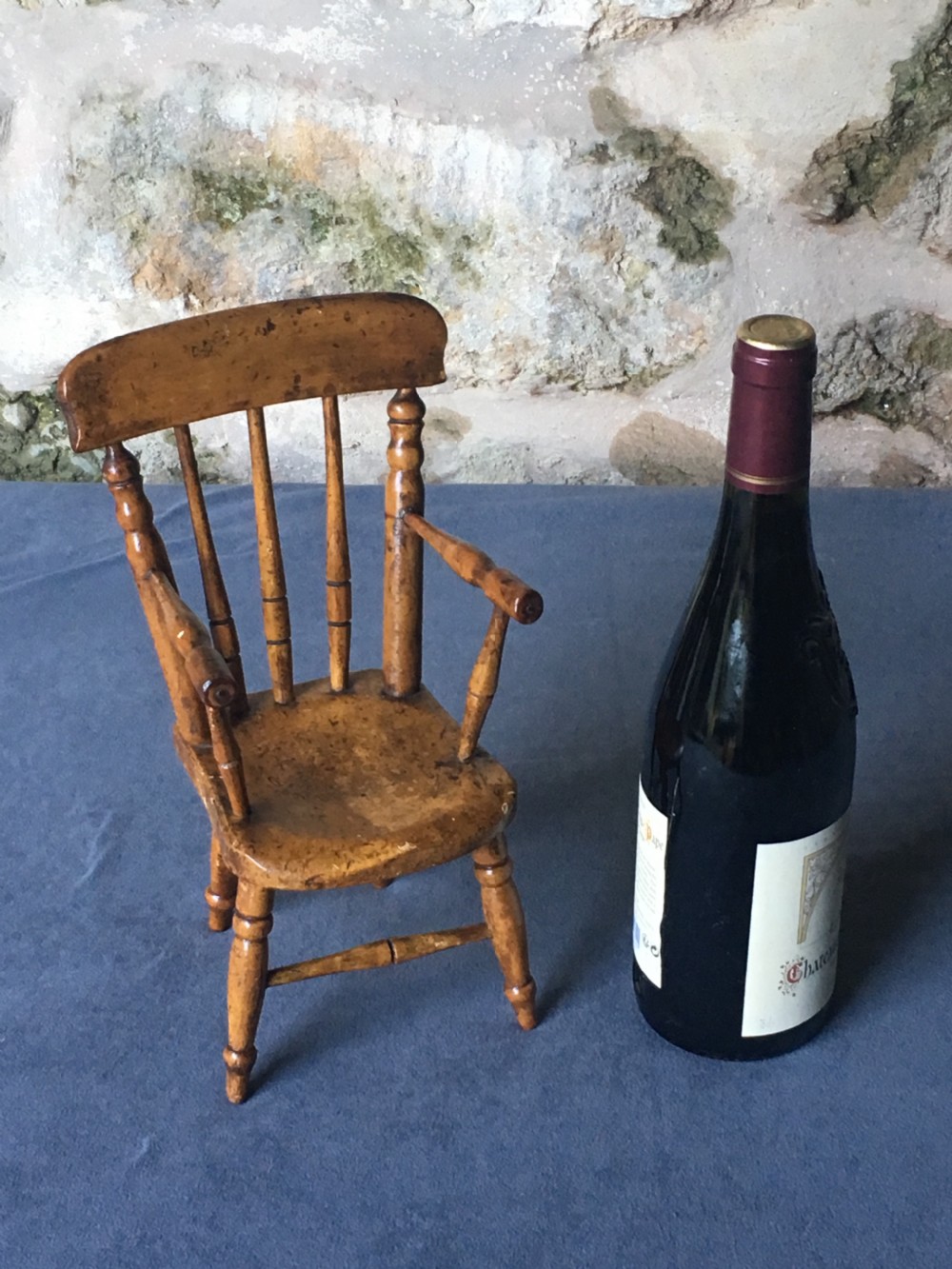 A wooden miniature Windsor armchair featuring turned spindle back supports, curved armrests, and turned legs. View XI