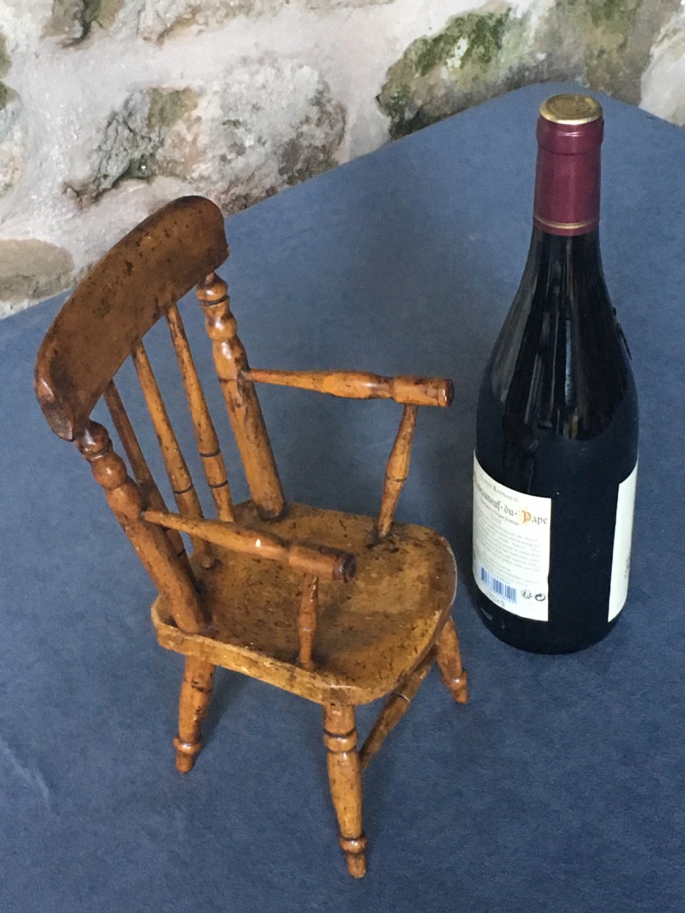 A wooden miniature Windsor armchair featuring turned spindle back supports, curved armrests, and turned legs. View XII