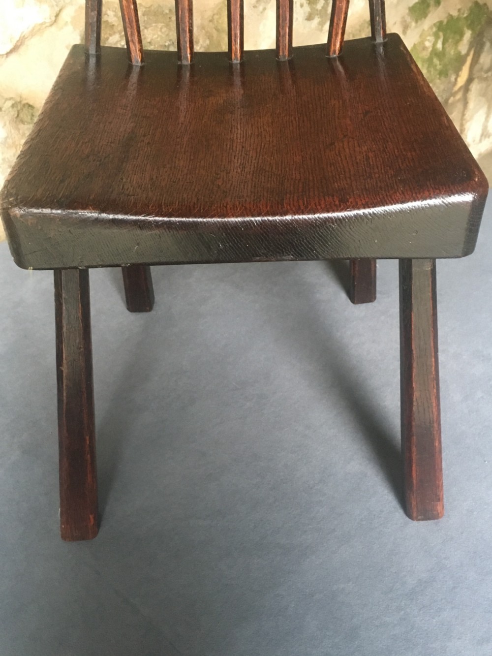 A dark oak side chair featuring a spindle back rest, solid wooden seat, and tapered splayed legs. View VII