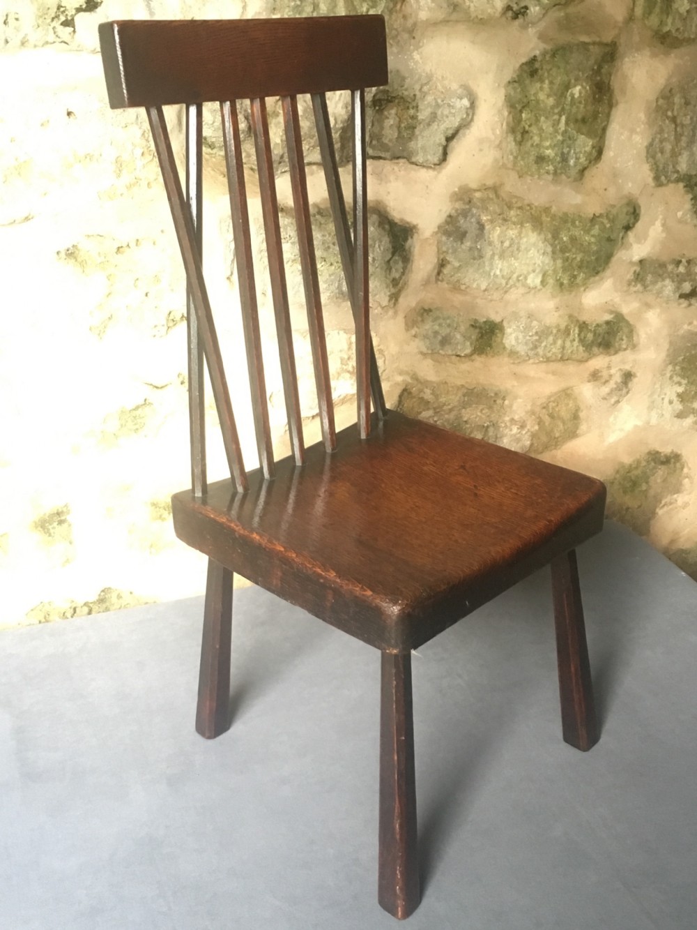 A dark oak side chair featuring a spindle back rest, solid wooden seat, and tapered splayed legs. View VIII